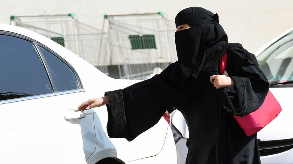 Wanita muslimah arab saudi memasuki mobil.