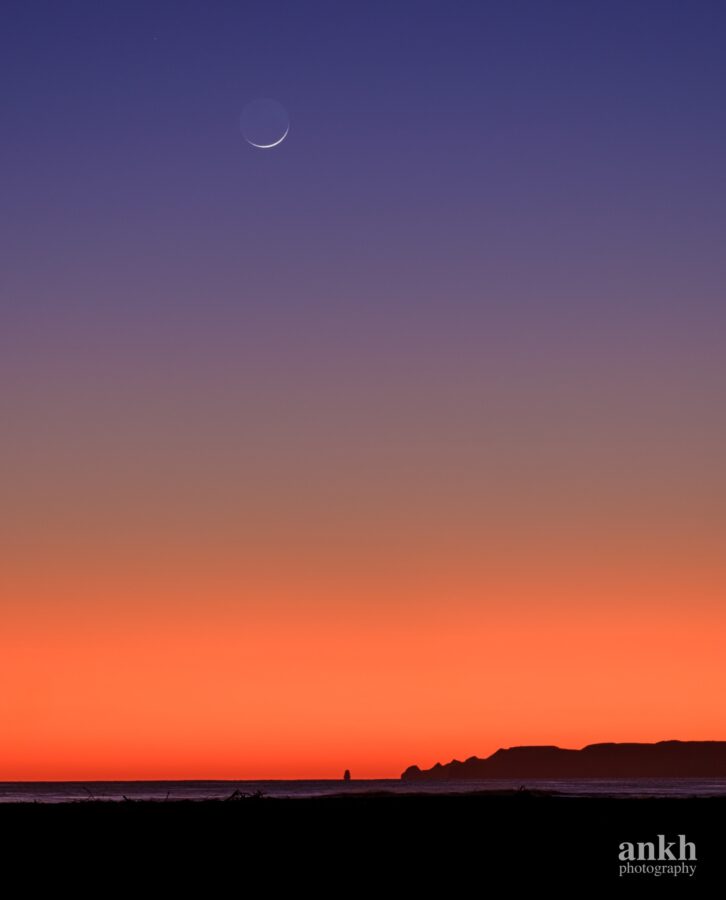 Thin crescent moon rises over Cape Kidnappers just before sunrise, Hawke's Bay, New Zealand by Ankh Photography. This is the last visible crescent moon of islamic month Jumadal Akhirah 1444 AH that precedes Rajab.